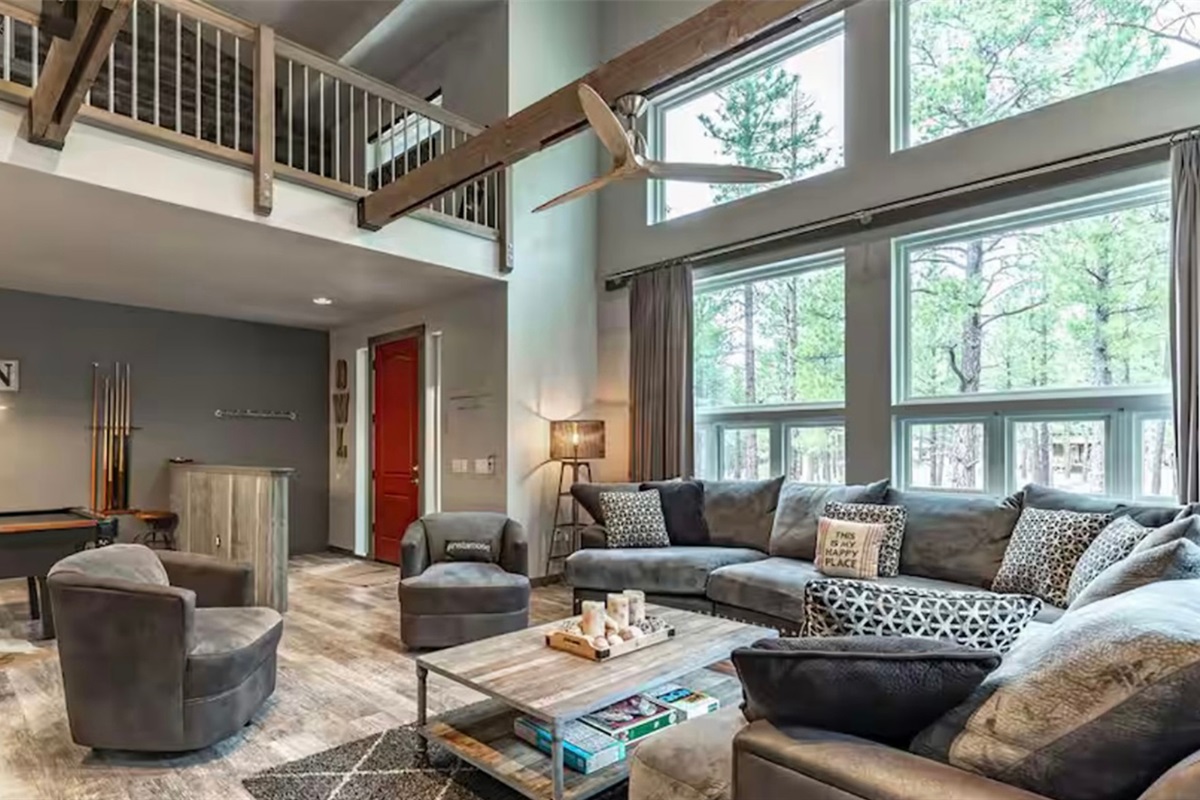 Bright great room with soaring windows bringing the tall pines indoors.