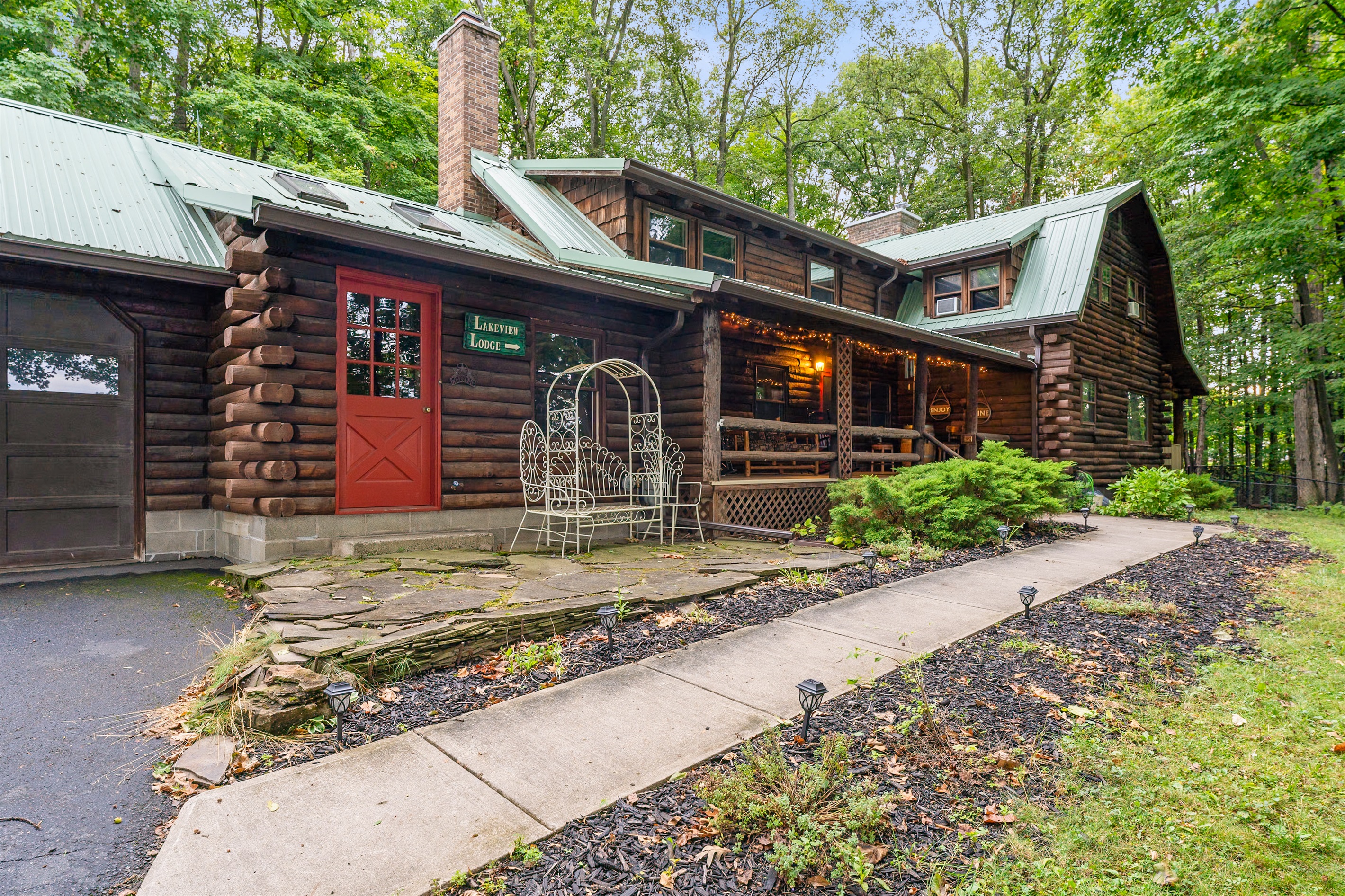 Charming log cabin retreat with rustic details, inviting front porch, and serene wooded surroundings—ideal for a cozy getaway.