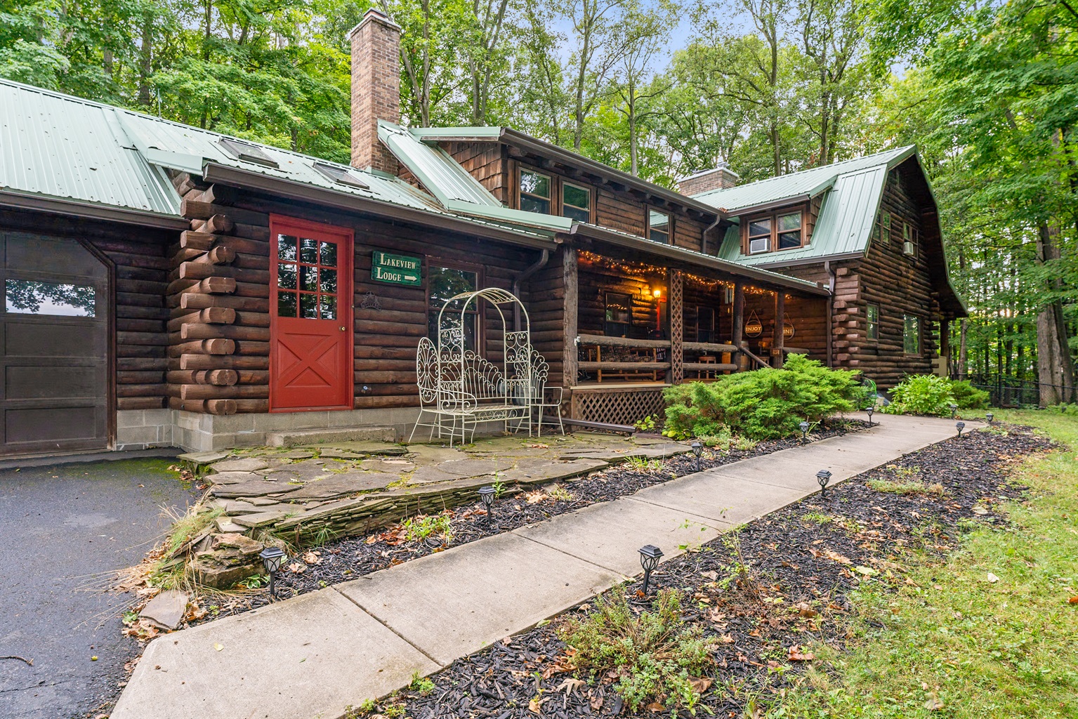 Charming log cabin retreat with rustic details, inviting front porch, and serene wooded surroundings—ideal for a cozy getaway.