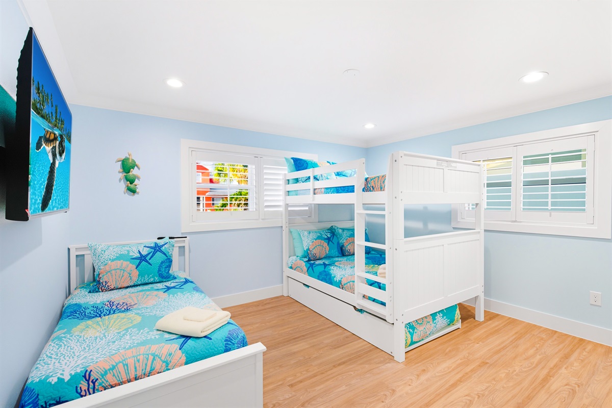 Bedroom 3 offers a twin bed, full bunk beds, smart TV and large closet.
