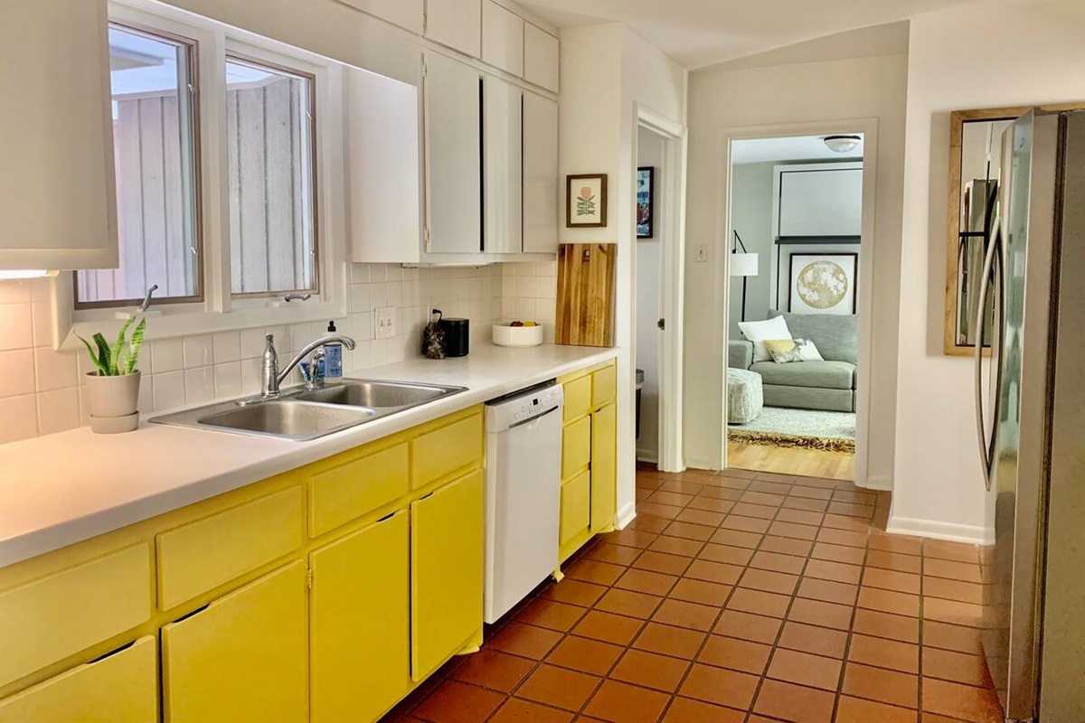 The mid-century galley kitchen has stainless steel fridge, gas range, and dishwasher. FULLY stocked kitchen for those who like to cook. Pots, pans, sharp knives, olive oil, spices, all kitchen tools, cast iron pans, food processor; we've got it all. 