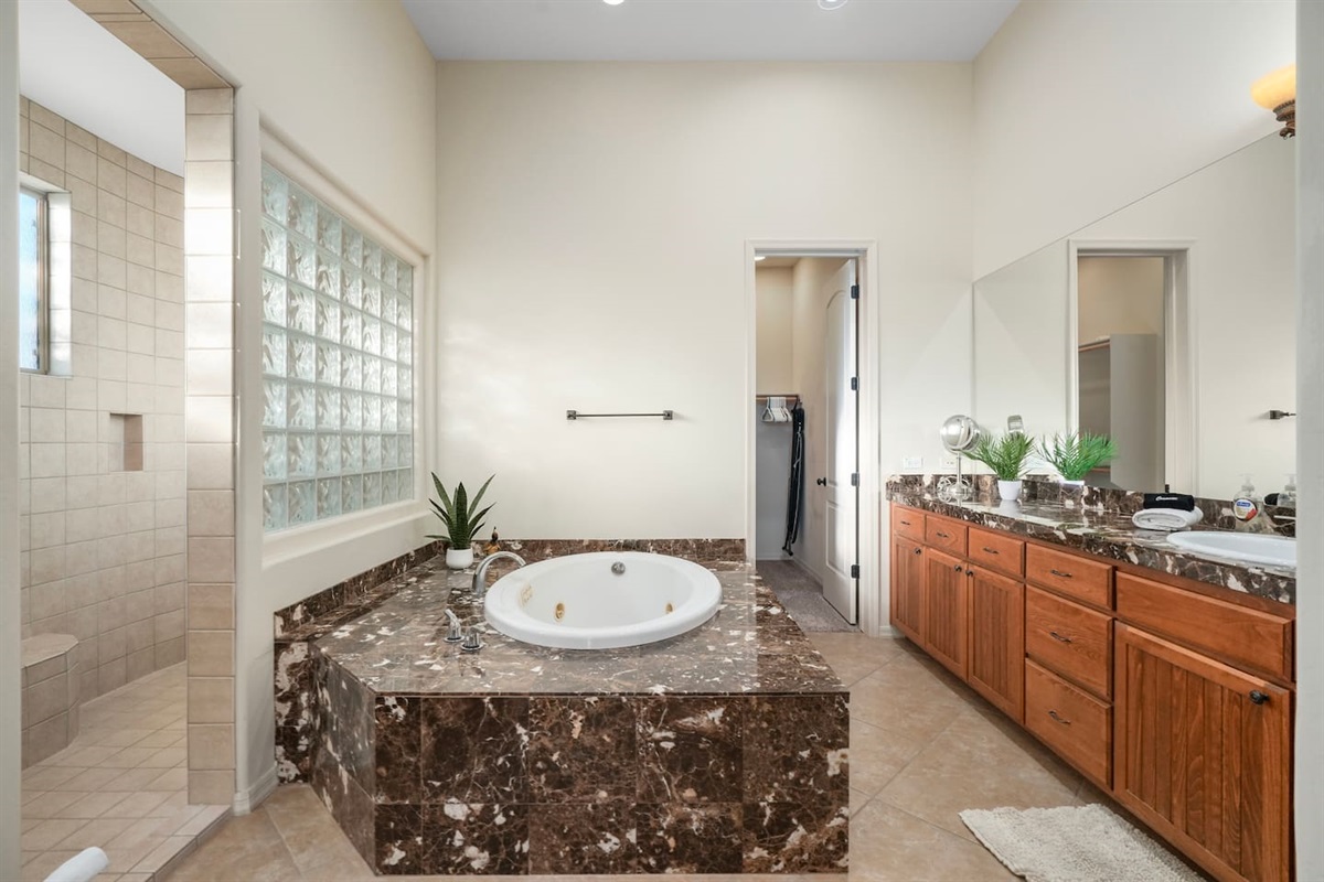 Spacious primary bathroom with soaking tub, walk-in shower, and dual vanity.