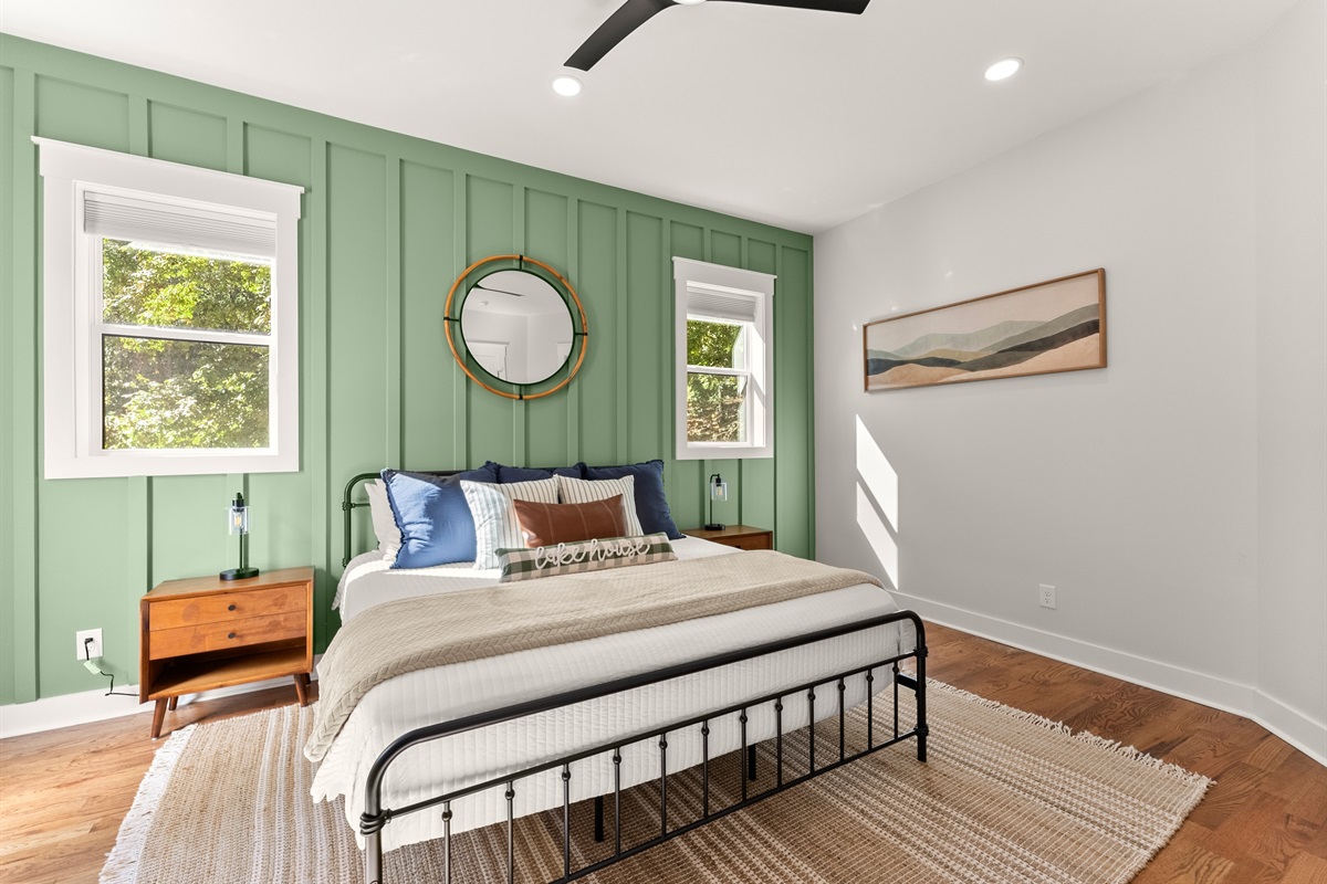 Serene bedroom retreat with TV, lake-inspired décor, and ensuite bath.