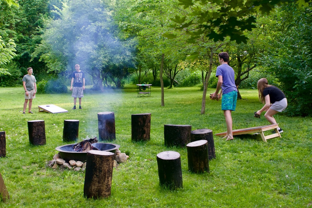 Roast something over the fire or play a competitive game of corn hole.