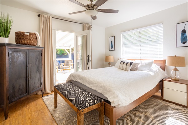 Queen bedroom with flat screen TV and walk out porch with lounge area.