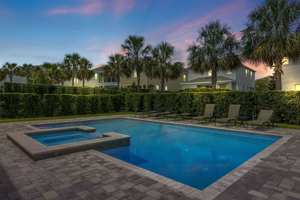 Experience evening tranquility by the poolside, where sunbathing chairs await amidst lush greenery. The warm glow of sunset casts a magical ambiance, complemented by soft lighting, creating a perfect setting for relaxation and memorable moments.