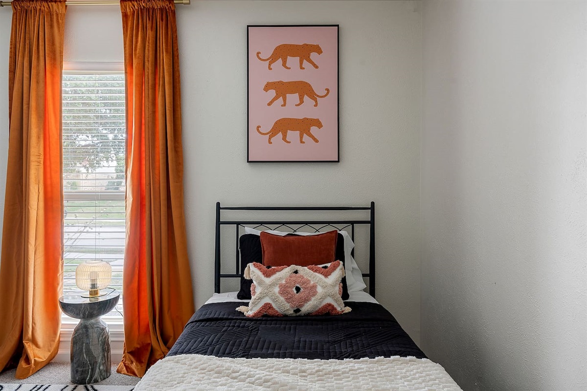 Enjoy the appeal of this tiny room, which includes distinctive wall art and a comfortable single bed. Natural light enters through the huge window.