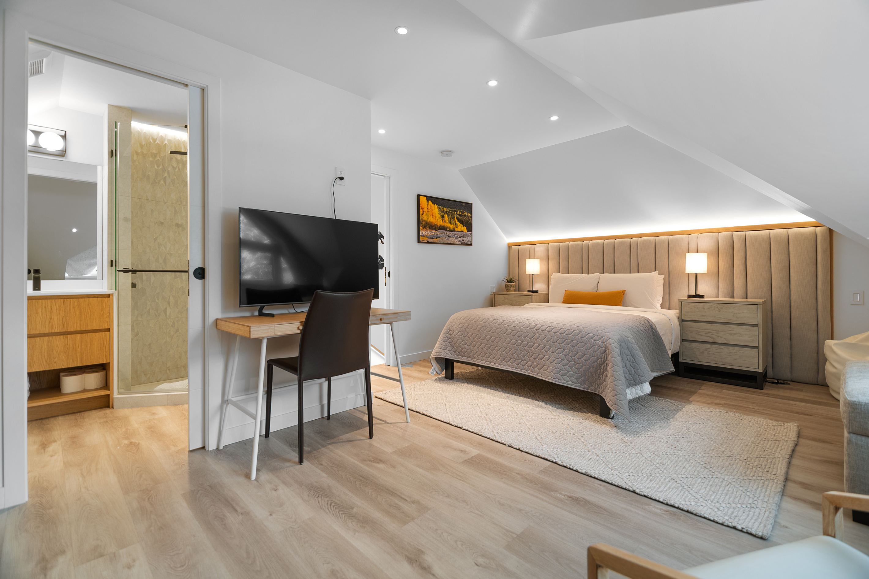 Primary bedroom desk, TV and ensuite door