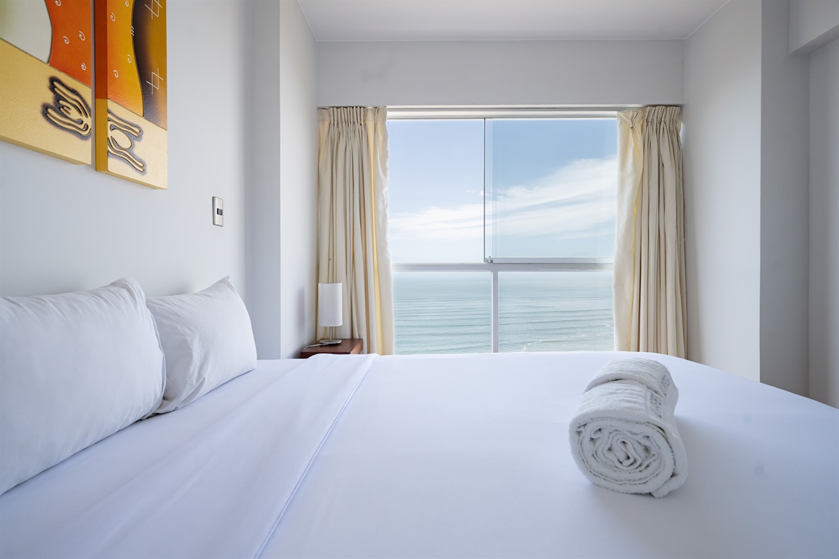 Modern comfort with a queen bed and unforgettable views of the ocean and Malecón  /  Cama queen y vistas inolvidables al océano y al malecón