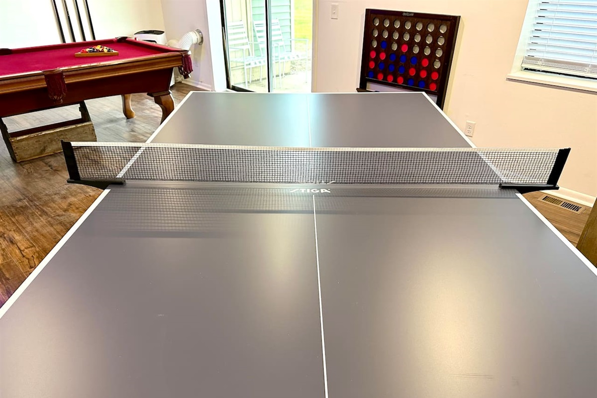 Spacious shared game room with pool table, ping pong, Connect 4, TV, board games and casual seating—perfect for relaxing or friendly competition after a day of adventure. Great for groups and families looking for fun during their stay!