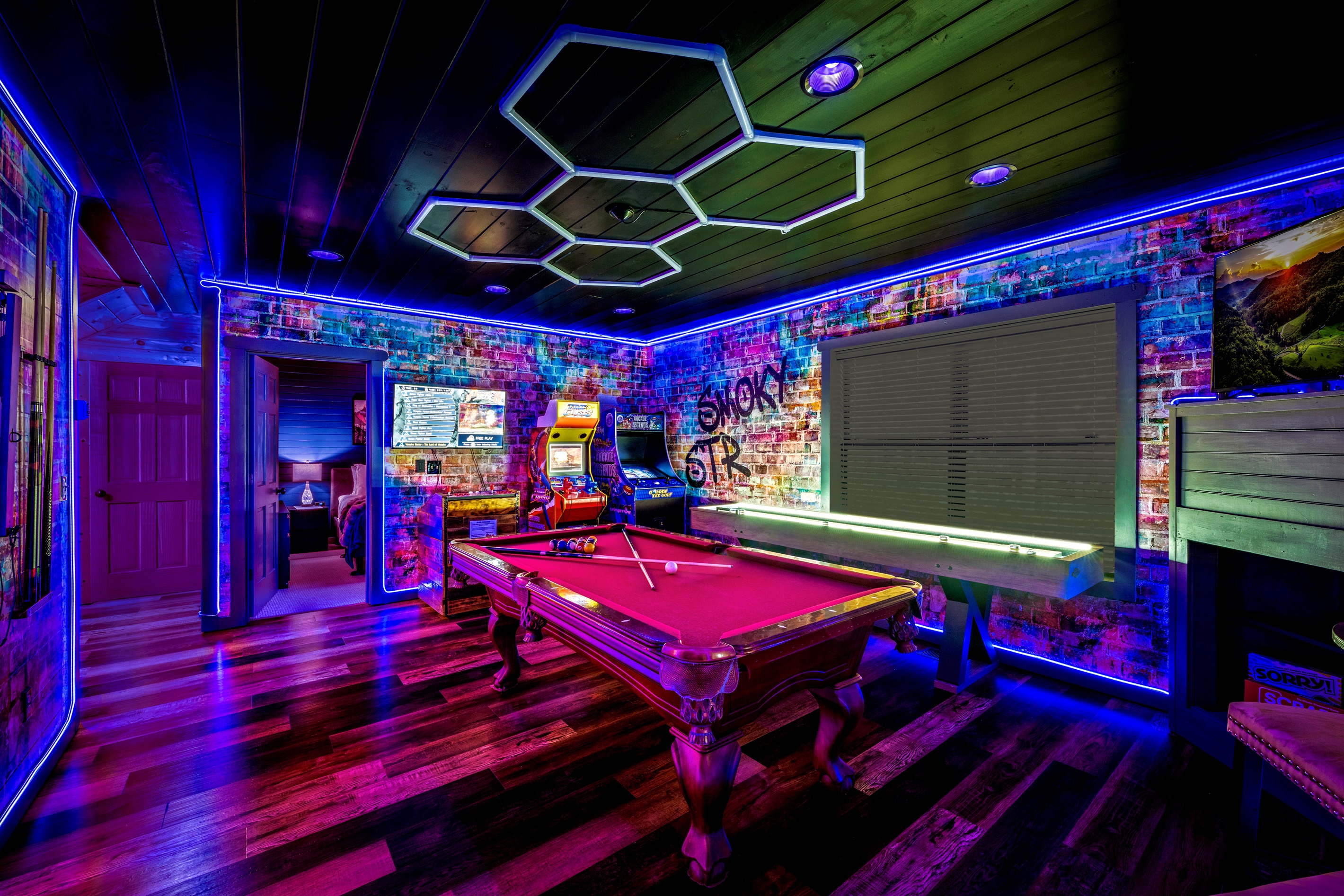Epic game room with 3 arcades, shuffleboard, billiard pool table, streaming roku TV, board games, and a dart board. The arcades include a 1200 Game Pandora's Box, Time Crisis, and an old school 1980's game system 