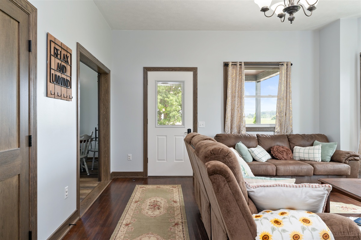 Warm entryway leading into a comfortable living space with plush seating and charming farmhouse details.