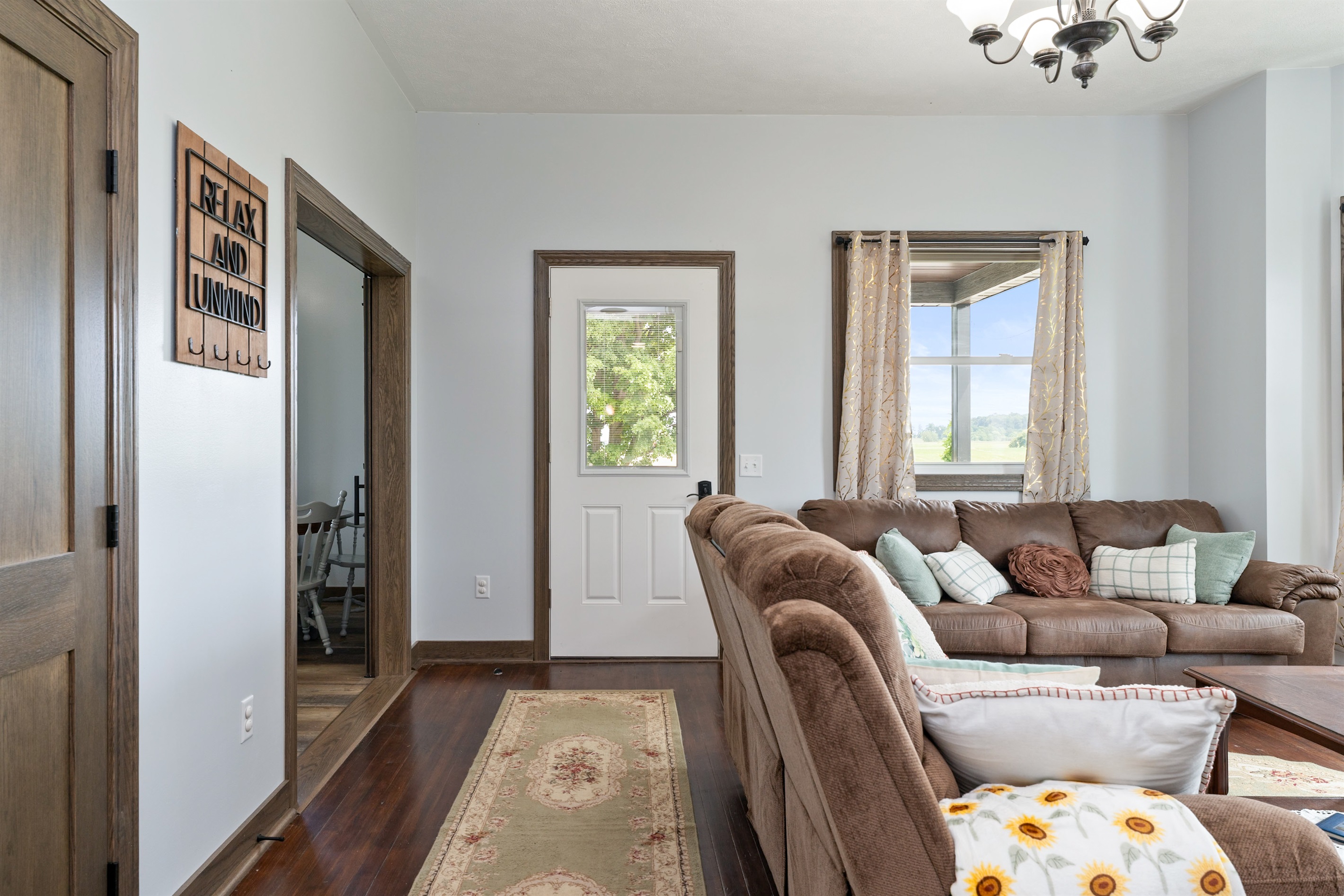 Warm entryway leading into a comfortable living space with plush seating and charming farmhouse details.