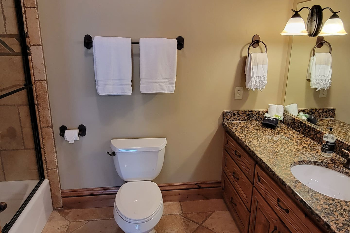 This well-appointed bathroom is maintained to the highest standards of cleanliness and comfort, featuring fresh, fluffy towels, a spacious vanity, and a convenient tub/shower combination—perfect for relaxing and refreshing during your stay.