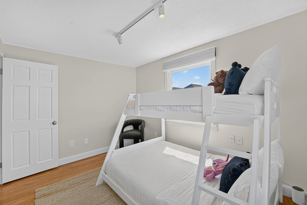Family-friendly bunk room offers comfortable additional sleeping space with plenty of natural light.