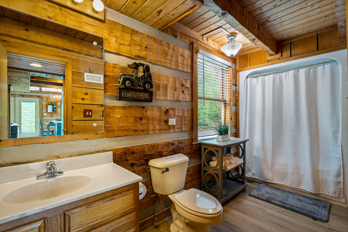 Main level bathroom, with a shower and tub. Laundry area is located in the closet.