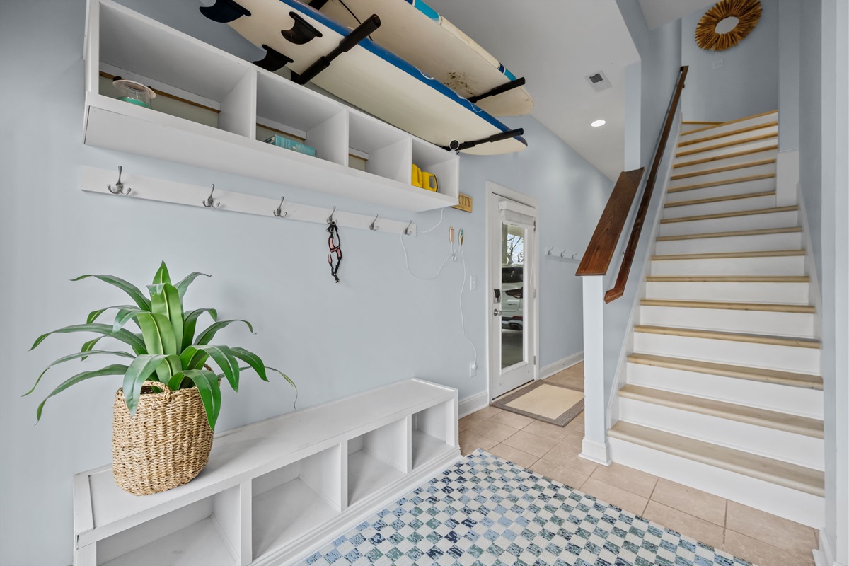 Ground floor entry way "drop station"- plenty of room to hang beach bags, store flip flops, or park your jogging stroller. Stairway leads to first floor bedrooms and laundry nook (Yes! Guests are welcome to take one of the surf boards out for a spin!)