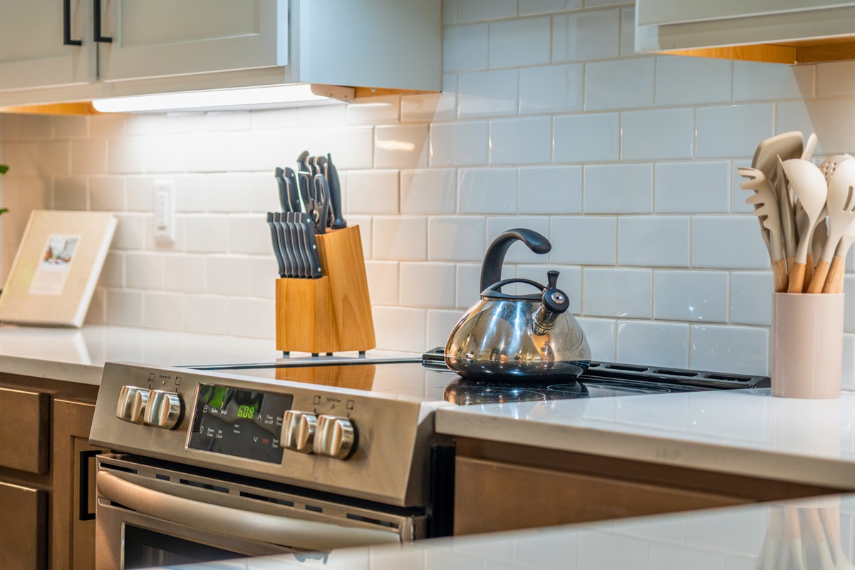 Thoughtful touches in the kitchen include modern cookware, knife set, and a welcoming home feel.