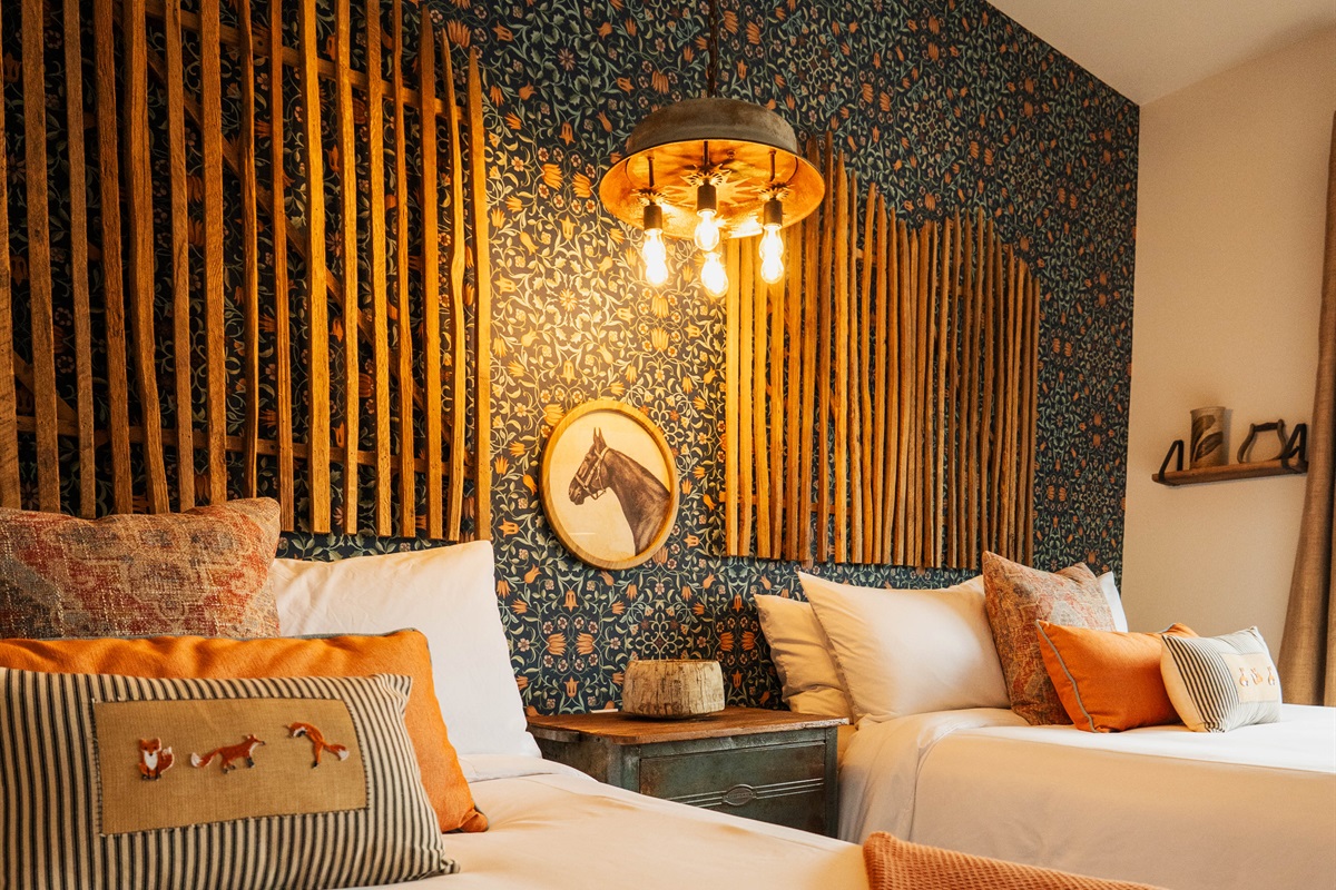 Pendant lighting and the bamboo feature wall at the Corral Suite — layered modern Western design over two queen beds.