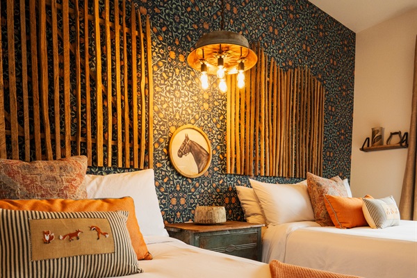 Pendant lighting and the bamboo feature wall at the Corral Suite &mdash; layered modern Western design over two queen beds.