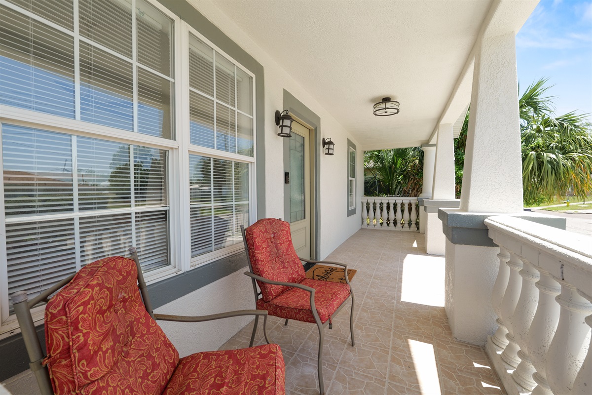 Start your mornings or wind down your evenings on this spacious front porch—complete with cozy cushioned chairs and peaceful palm views.
