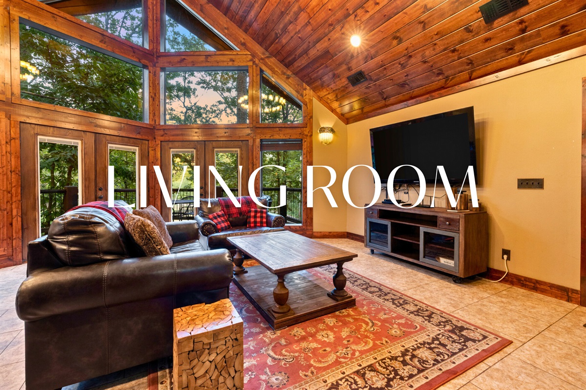 Bright living room with forest views and plenty of cozy seating.