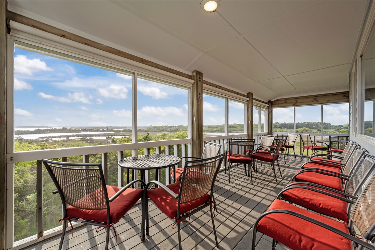 Screened-in porch with dining and seating&mdash;enjoy meals with stunning water and marsh views