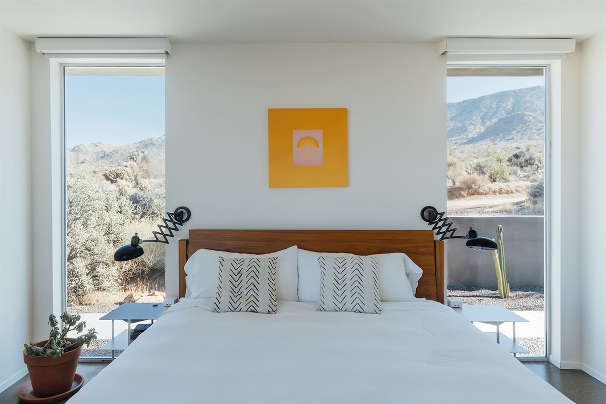 Rest easy in the modern queen bed surrounded by floor-to-ceiling windows that fill the room with natural desert light.