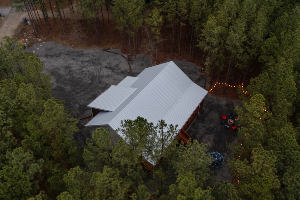 From above, you can see how the cabin sits comfortably within the tall pines, offering a quiet retreat that feels both secluded and inviting.