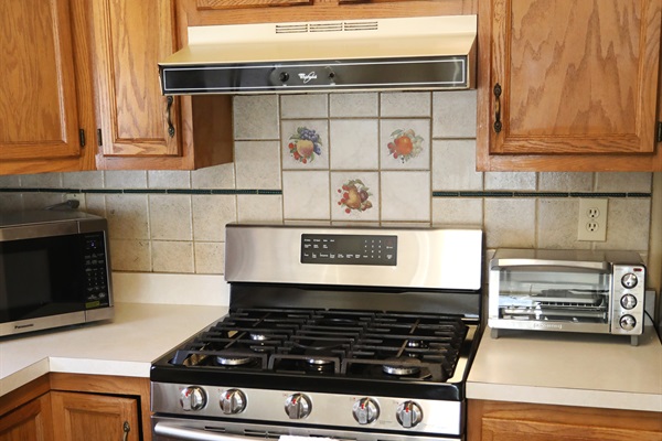 Kitchen showing microwave, stove, toaster oven, and fridge, Laundry room is to the right