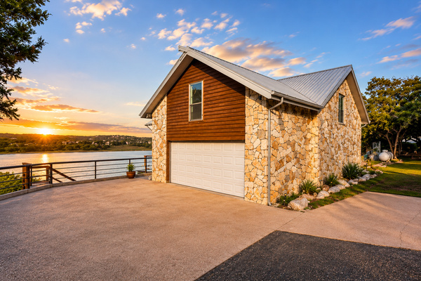 Charming Hill Country lake house with native stone exterior, private driveway, and beautiful sunset views over Lake Travis.