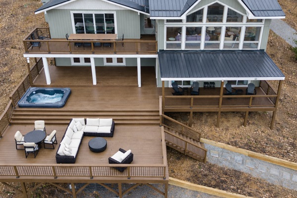 The expansive back deck—larger than the footprint of the home—offers multiple seating and gathering areas with uninterrupted views in every direction.