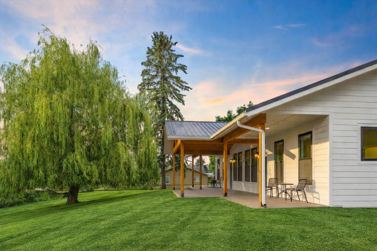 Large patio with extendable divider for privacy if other unit is occupied. (grass enhanced w/ AI)