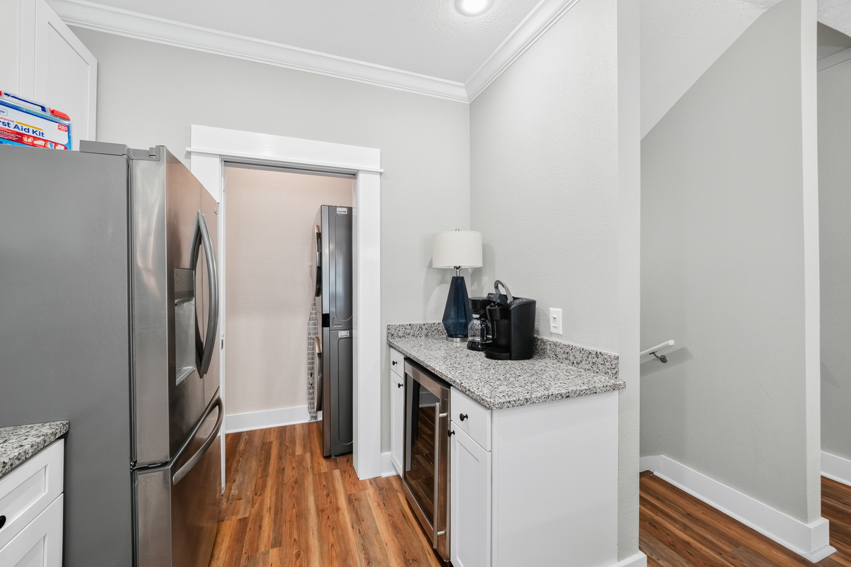 Bright, modern kitchen with full-size refrigerator, ice maker, coffee maker, and ample counter space for easy meal prep.
