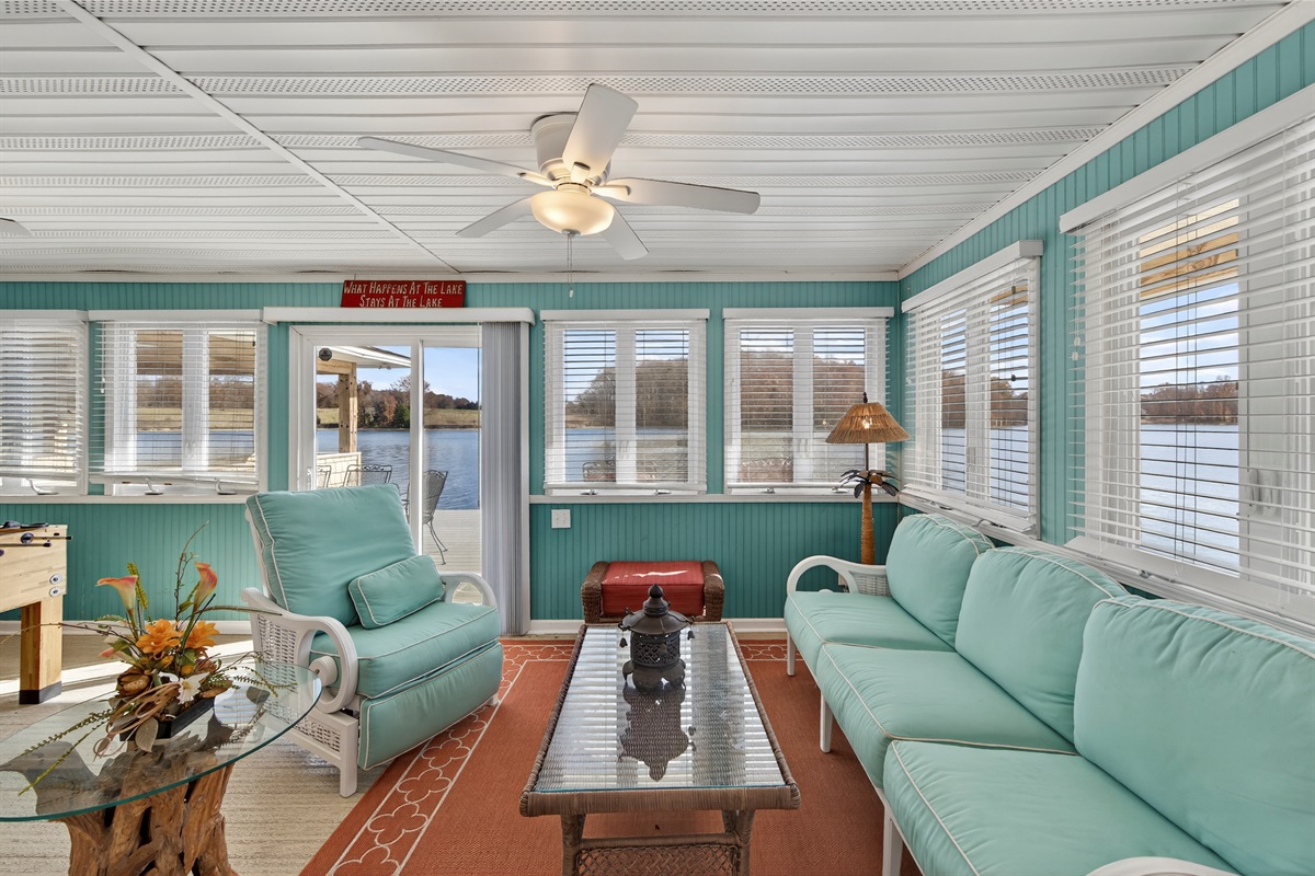 Spacious waterfront sitting area with wraparound windows and comfortable seating for the whole group.