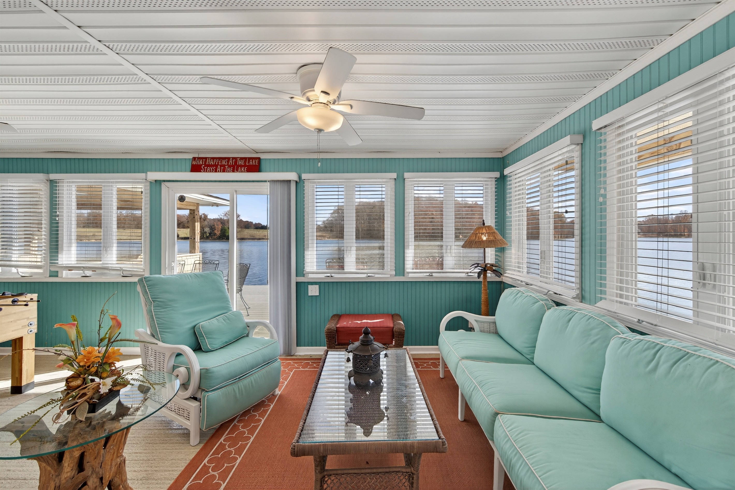 Spacious waterfront sitting area with wraparound windows and comfortable seating for the whole group.