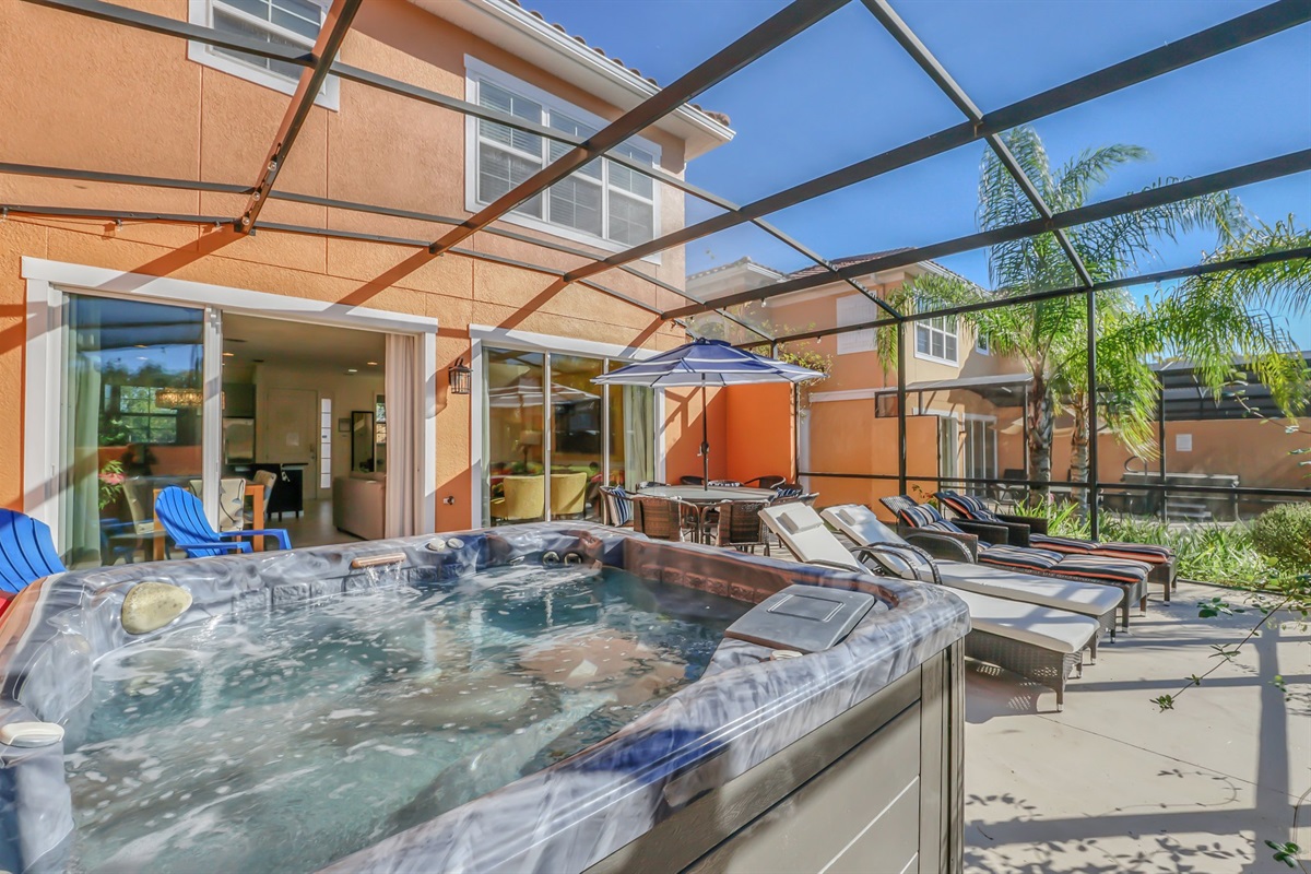 Private covered lanai with seating area, hot tub and lounge chairs
