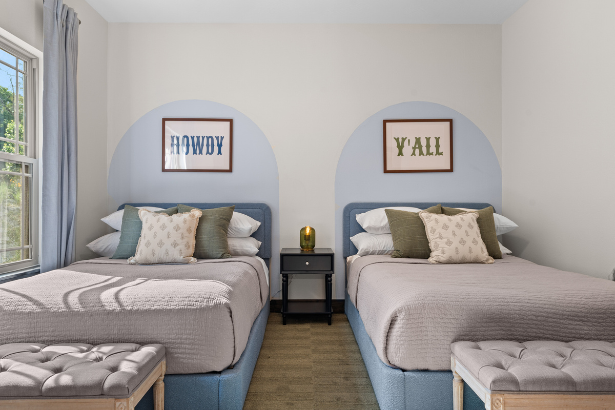 Also on the main level, 'Howdy' and 'Y'all' prints watch over the two arched-niche beds in the Austin room.