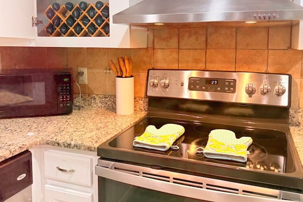 Stainless stove and stocked cookware make meal prep easy, whether you’re cooking for two or a group. 