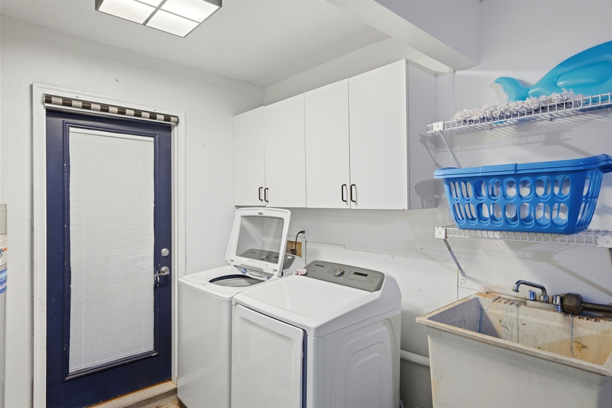 Convenience meets functionality with a dedicated laundry room featuring a washer, dryer, utility sink, and plenty of storage. Just steps away, the spacious two-car garage provides ample room for parking, storage, or additional gear during your stay.