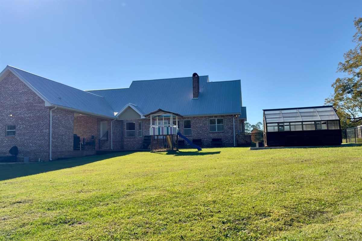  A children’s play structure with slide and climbing elements makes the yard inviting for younger guests.