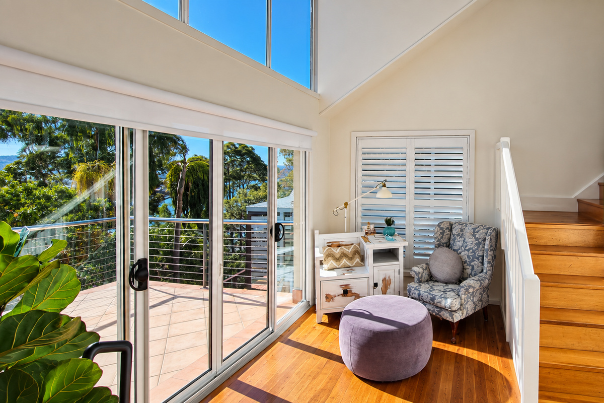 Sun-filled reading nook with comfortable seating and direct access to the balcony.