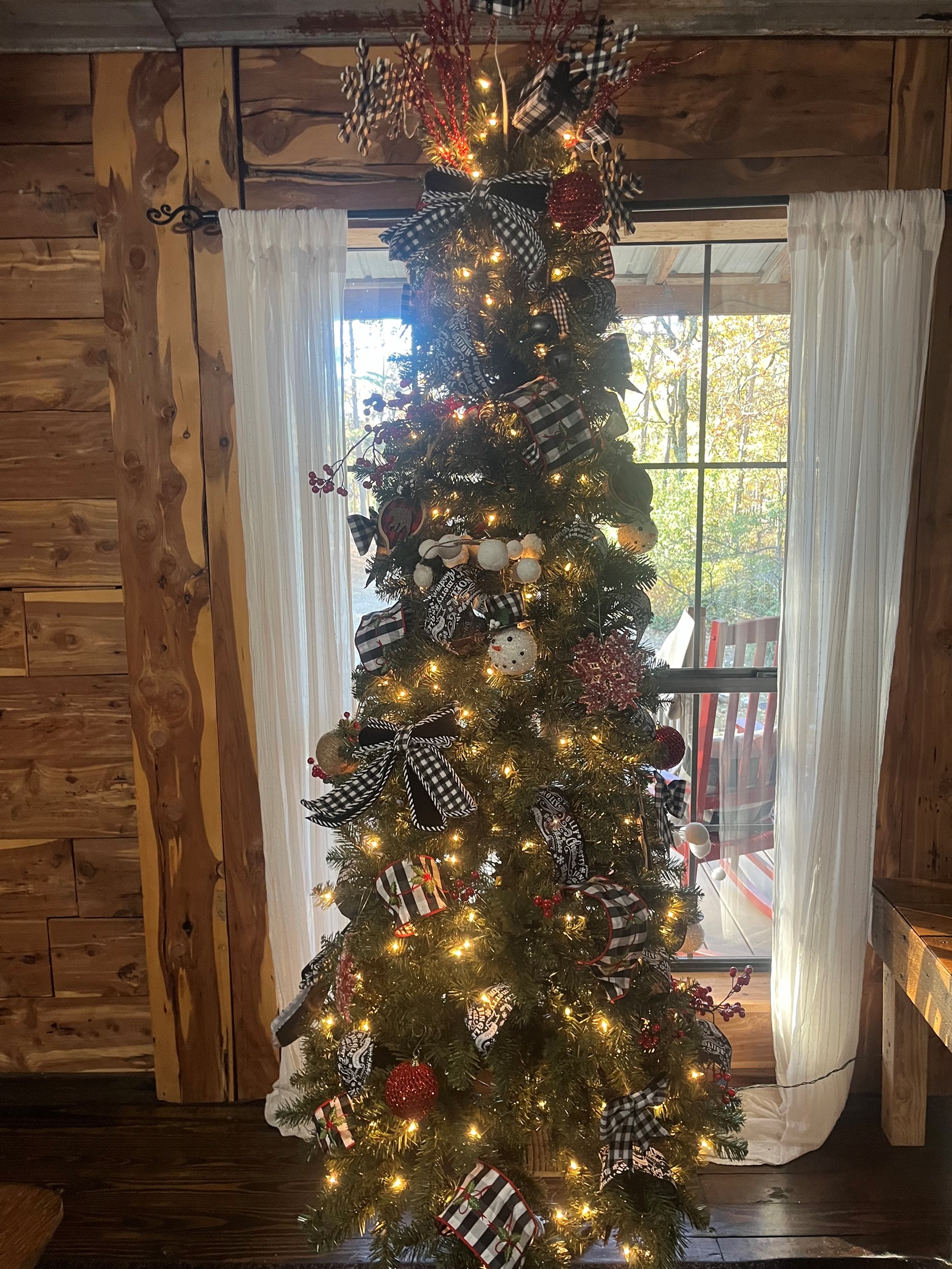 Christmas tree is fully decorated and displayed, bringing warmth and holiday cheer to the room.