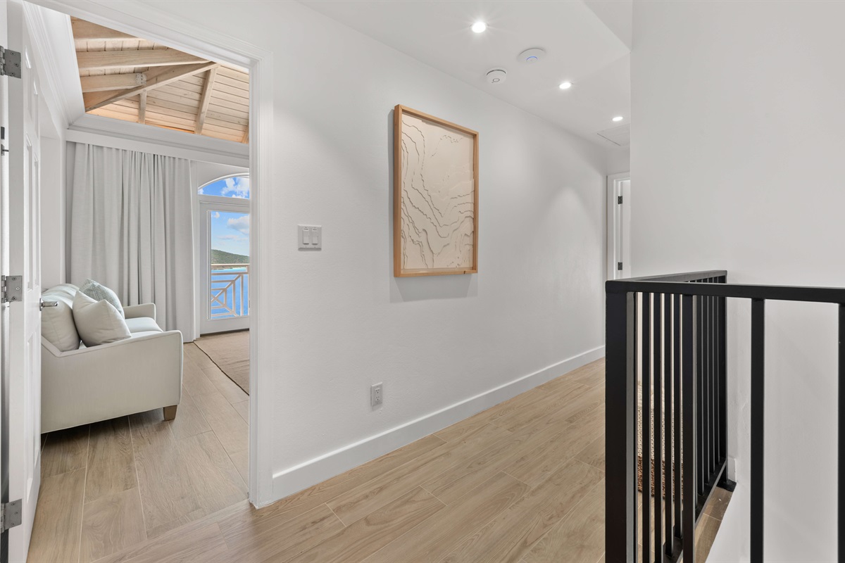 Open stairwell with natural light and modern railing design connecting both floors.