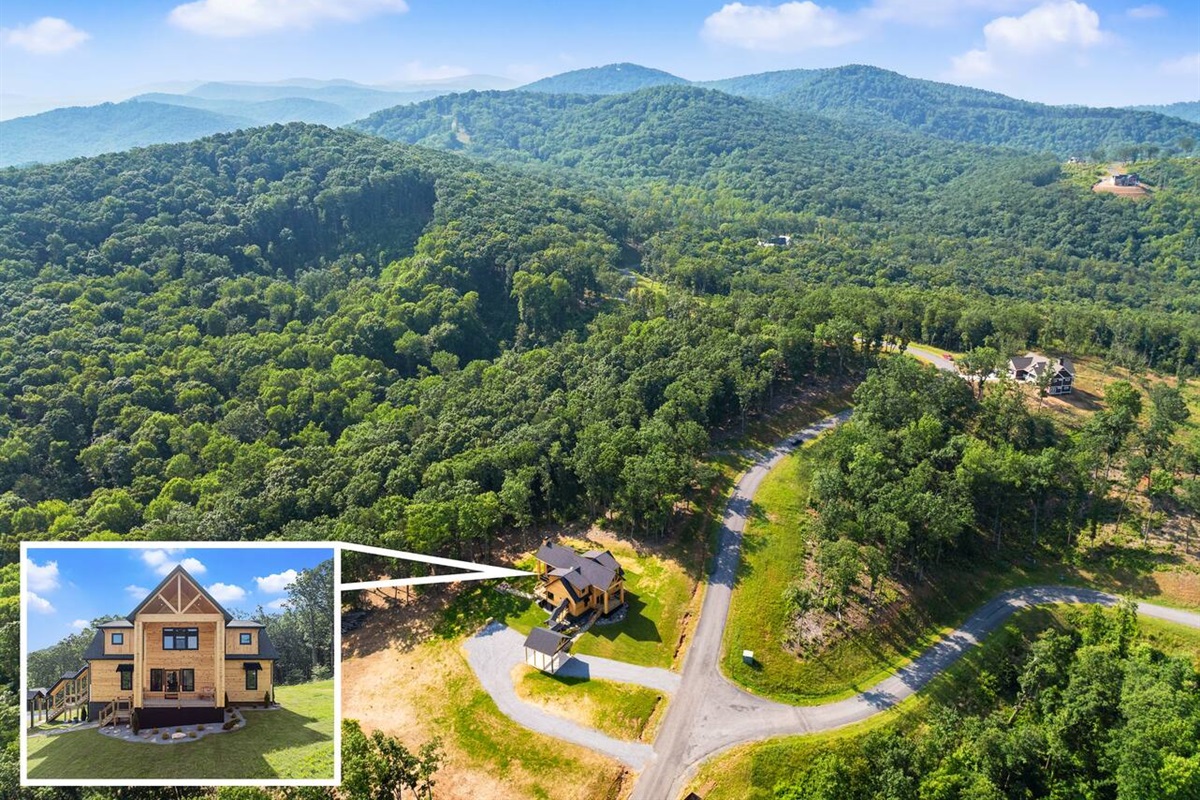 A stunning aerial view highlighting the lodge’s private setting surrounded by lush forest and mountain ridges.