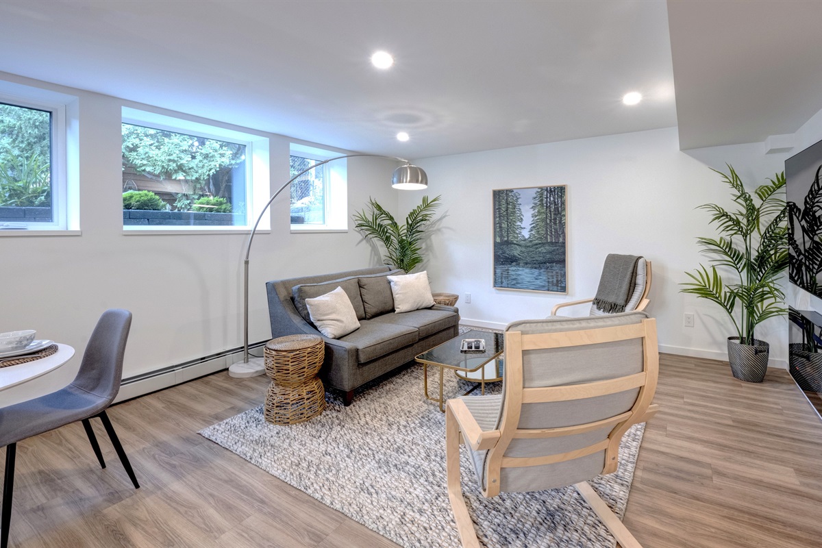 Bright living room with large windows and a calm, uncluttered layout.