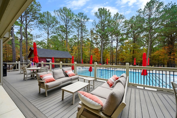 Spacious clubhouse pool area with plenty of lounge seating, shaded tables, and beautiful forest views—perfect for relaxing during your Broken Bow stay. 🏊‍♀️🌲✨