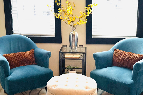 Two upholstered chairs create a comfortable conversation spot near the kitchen.