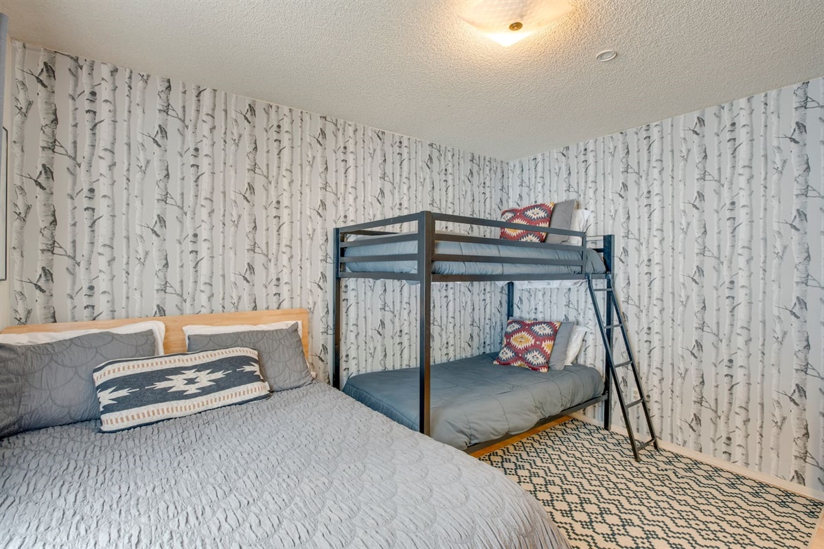 Downstairs bedroom with a bunk bed and a full size bed.