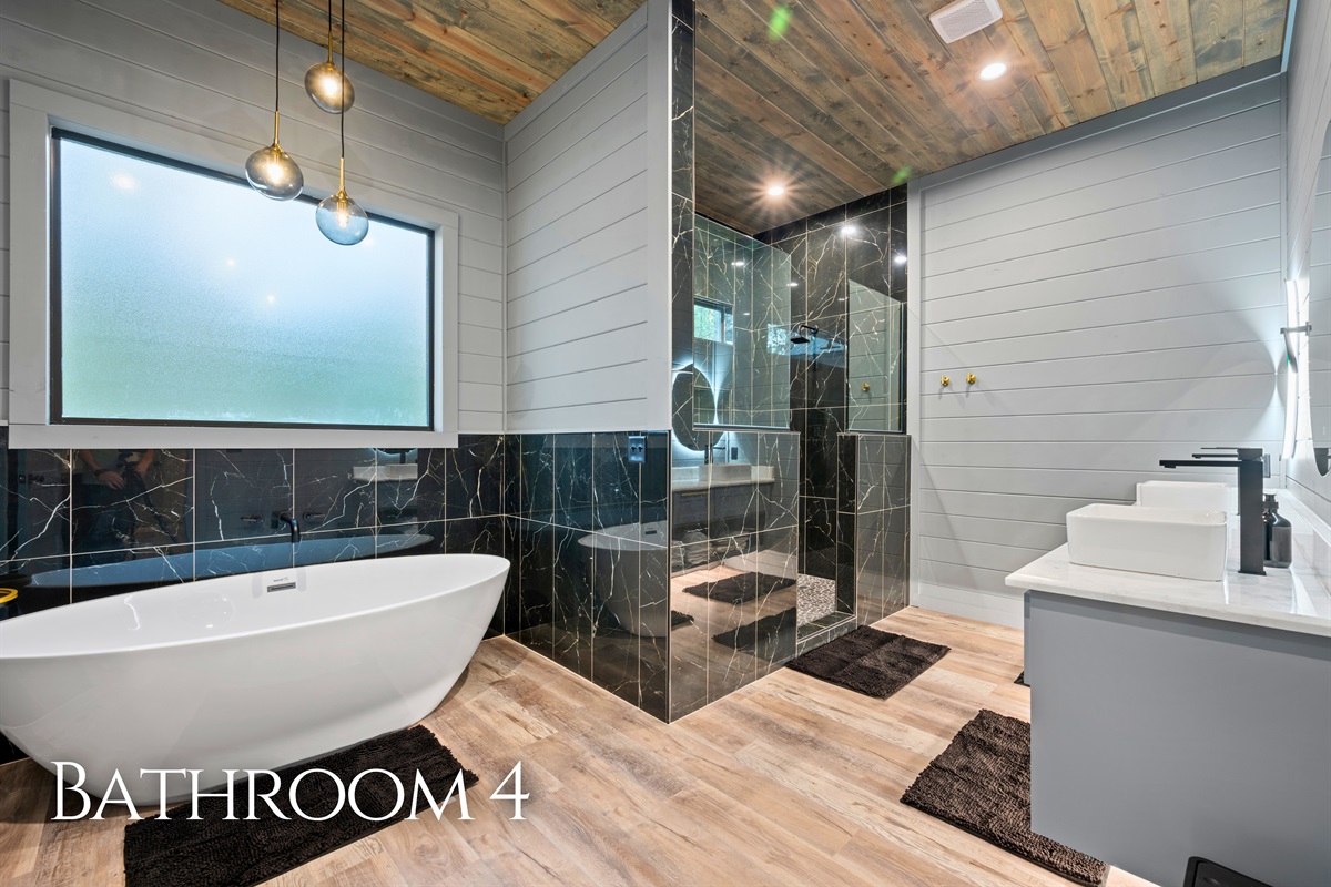 This spacious bathroom features a freestanding soaking tub and a large walk-in shower, offering the perfect blend of comfort and style.